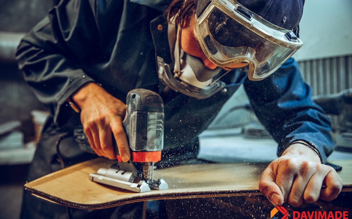 Carpenter using circular saw for cutting wooden boards.