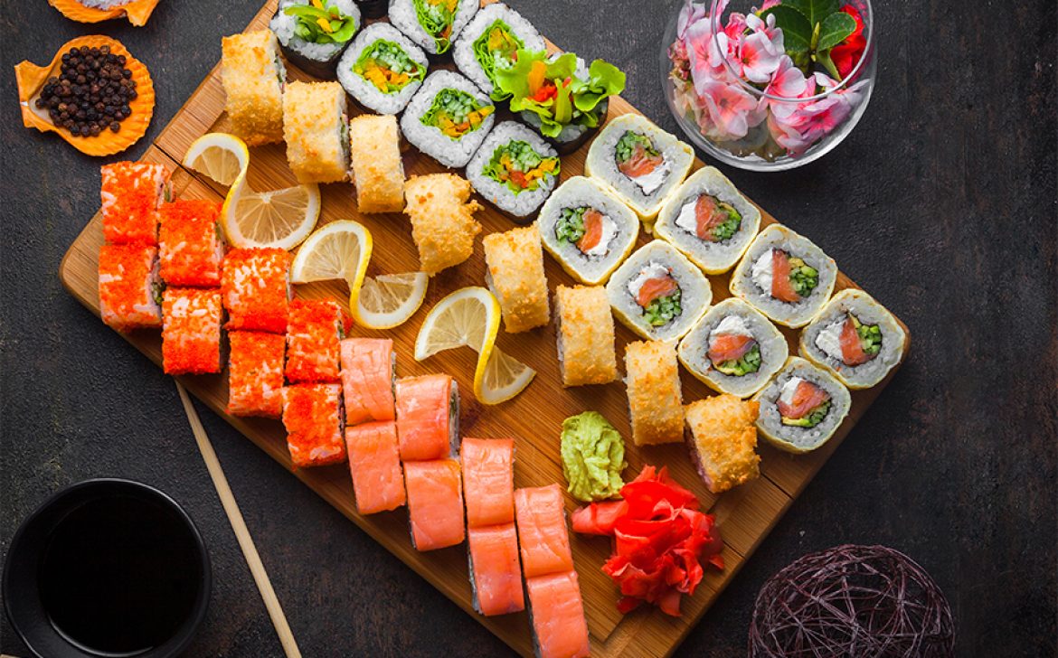 Top view sushi set with soy sauce and chopsticks in wooden servi